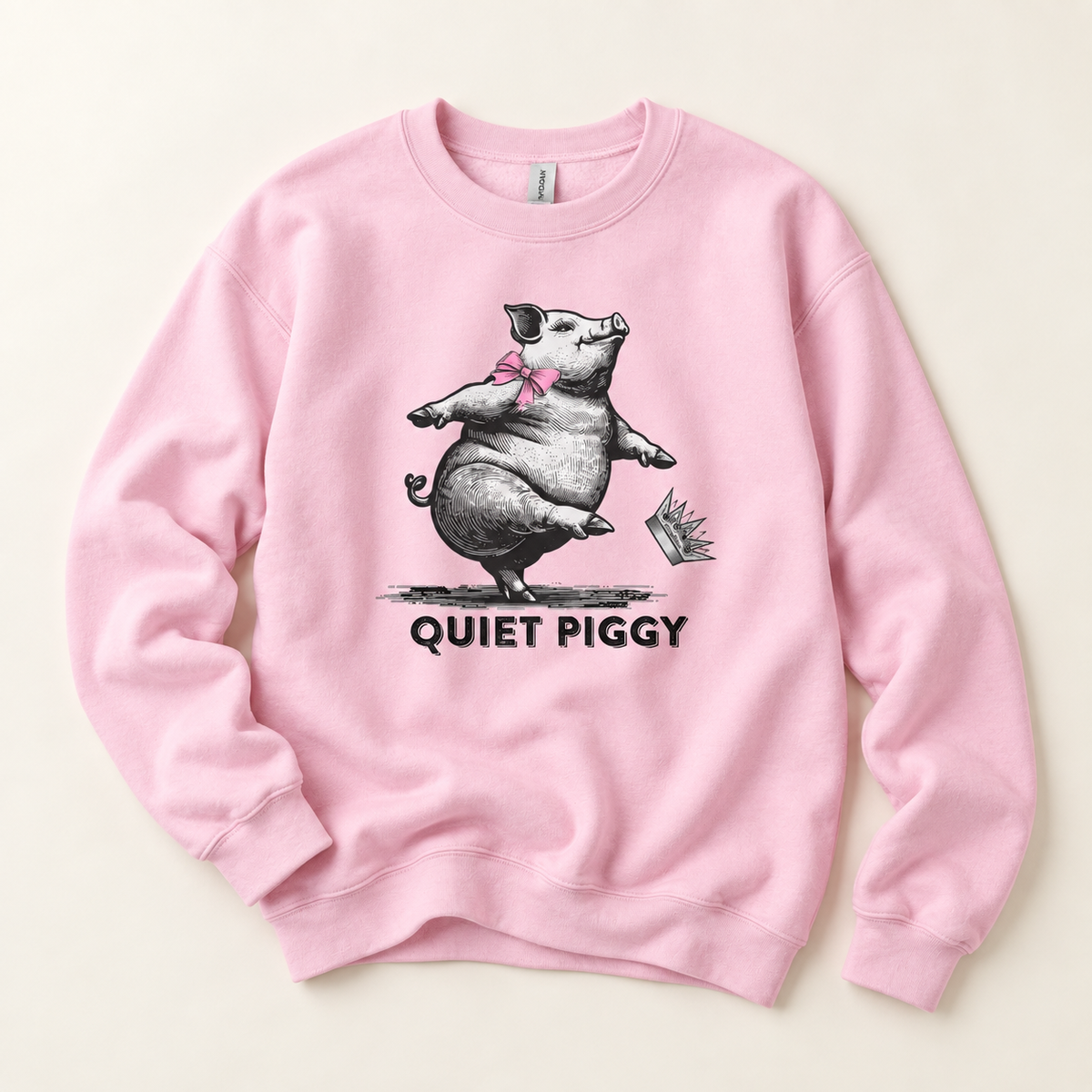 A light pink crewneck sweatshirt featuring a graphic of a cartoon pig wearing a pink bow and the text 'QUIET PIGGY' printed below, displayed flat against a light beige background.