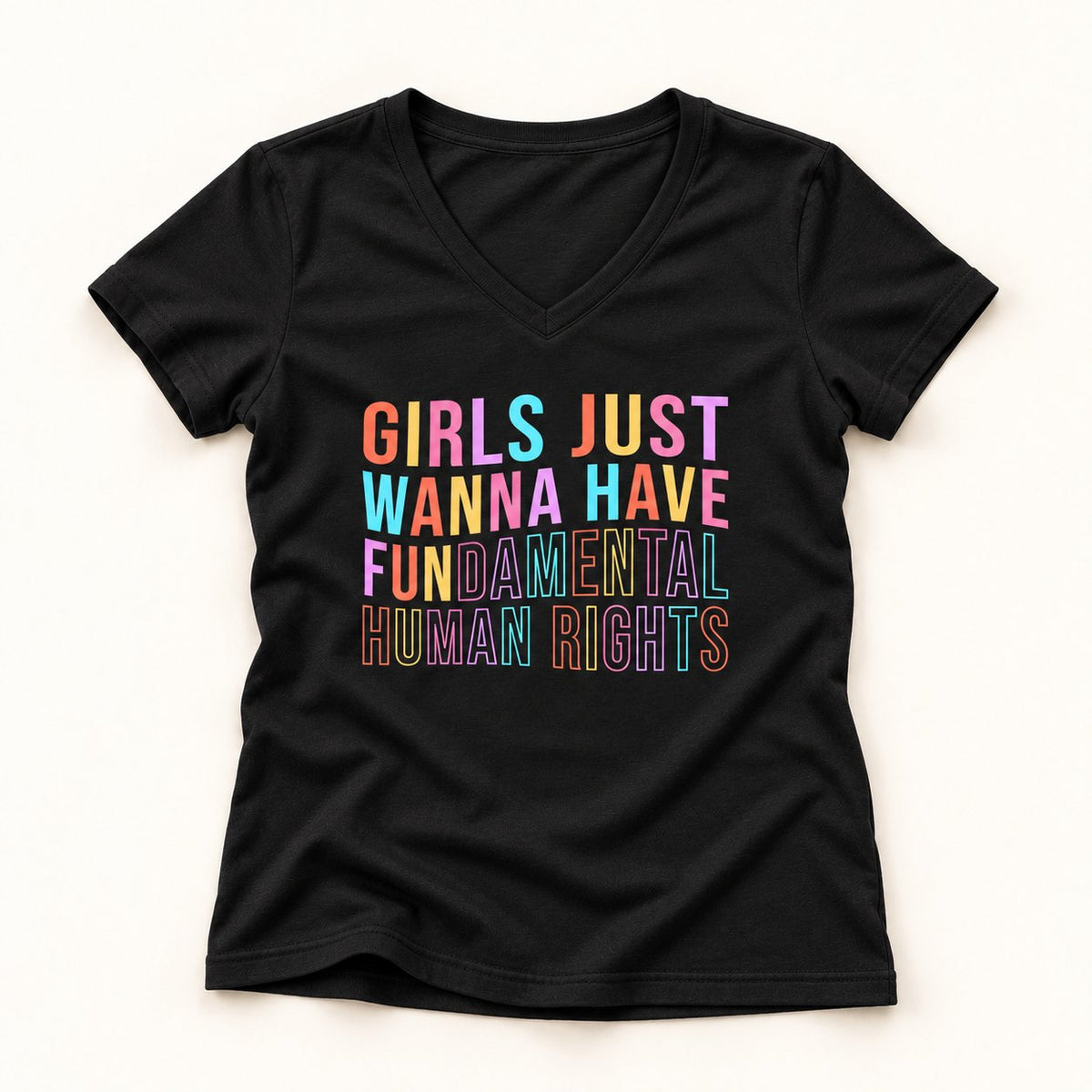 Girls Just Wanna Have Fundamental Human Rights V-Neck T-Shirt in Black, flat lay on warm off-white background