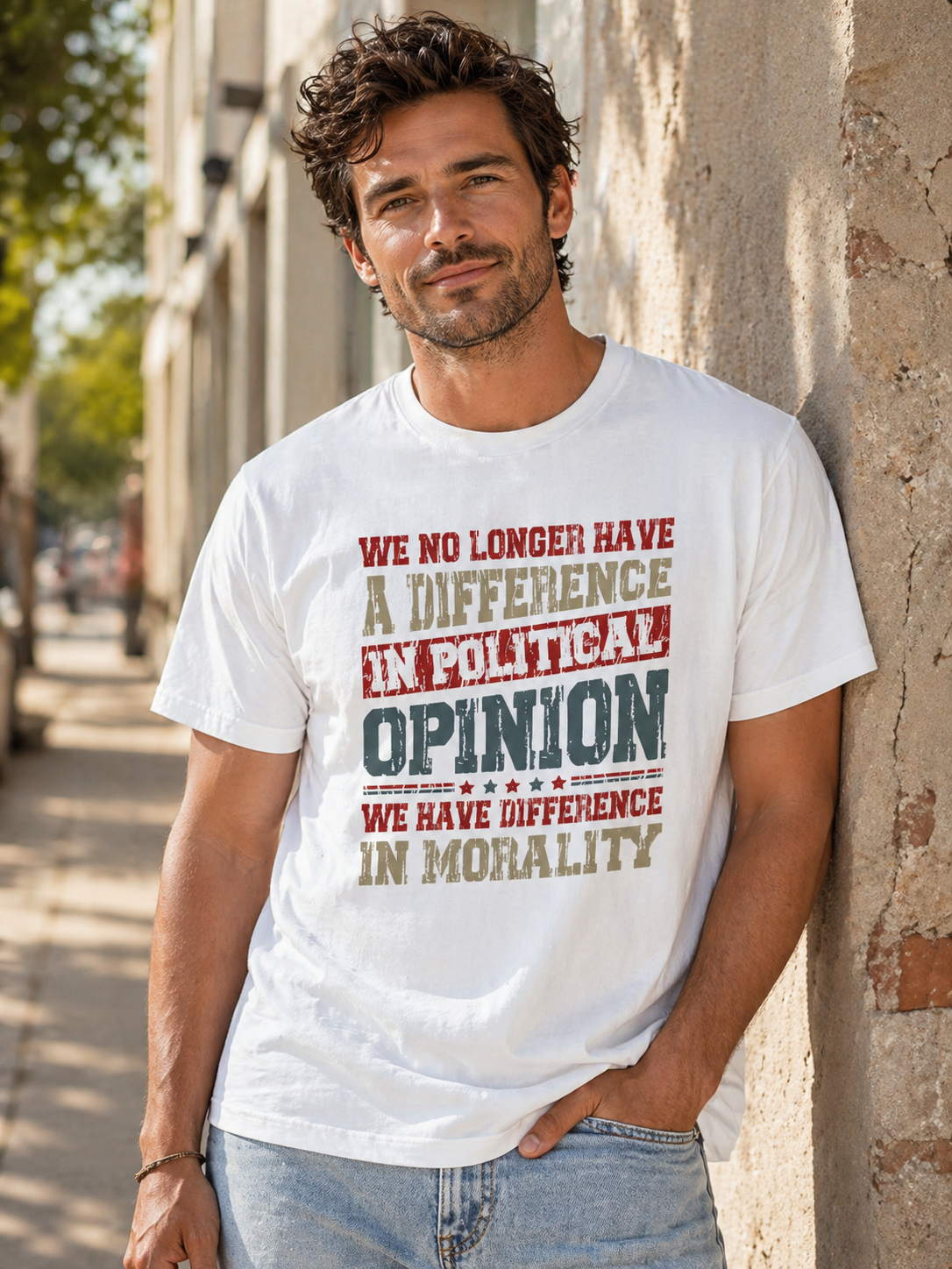 Man wearing a white t-shirt with a political message, standing against a wall.