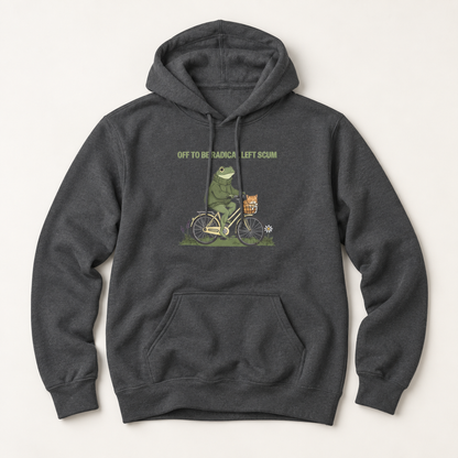 A dark heather gray pullover hoodie featuring a graphic of a green frog riding a bicycle with a basket, accompanied by the text 'OFF TO BE A TRAMPALE LEFT SCAM'.