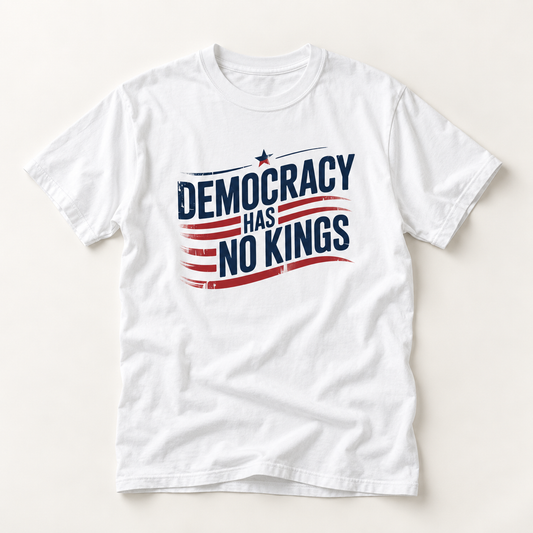 A white short-sleeve crewneck t-shirt with a distressed graphic on the chest that reads 'DEMOCRACY HAS NO KINGS' in navy blue text over red and navy stripes with a small star, displayed flat against a light beige background.