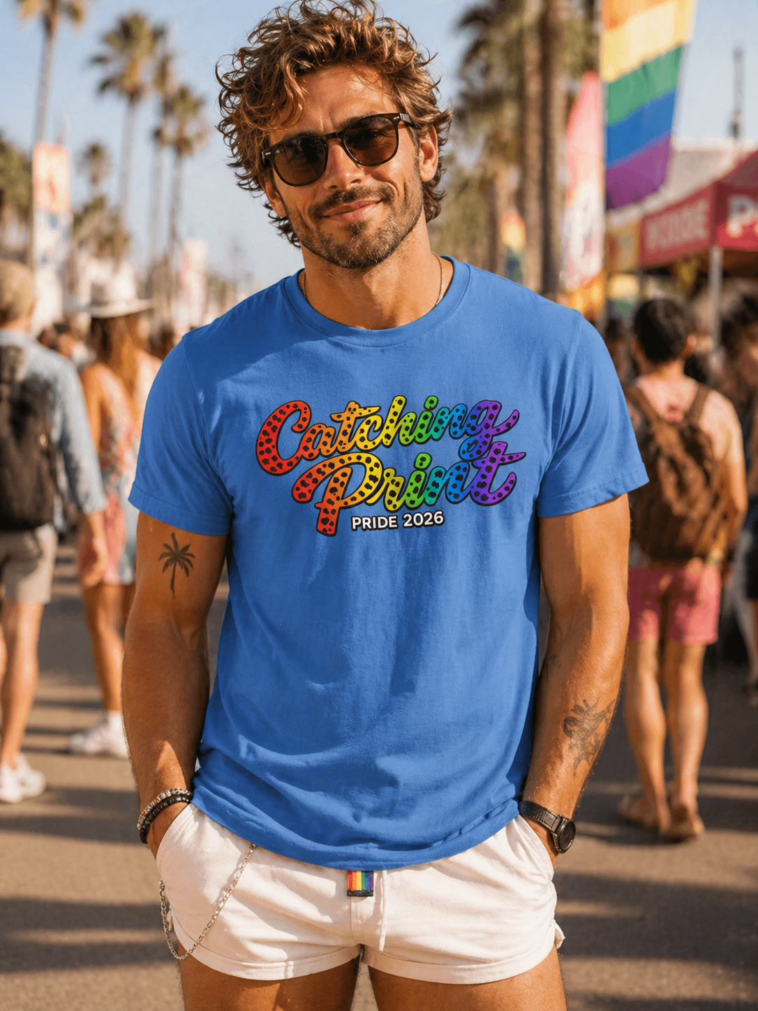 Man wearing a blue t-shirt with colorful text at a Pride event.