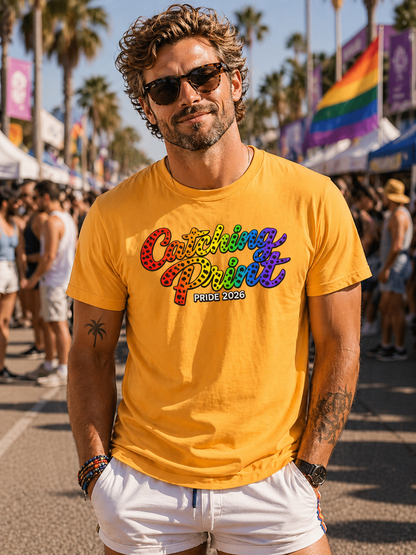 Man wearing a yellow t-shirt with colorful text at a Pride event.