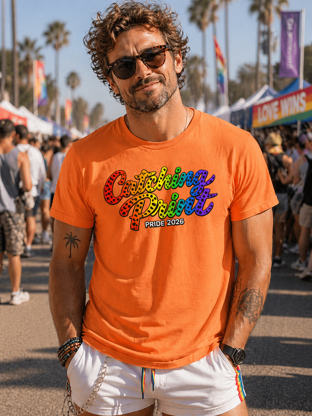 Man wearing an orange t-shirt with colorful text at a Pride event.