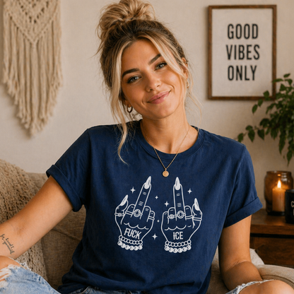 Woman wearing a blue t-shirt with graphic designs sitting in a cozy living room.