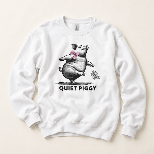 A white crewneck sweatshirt featuring a black and gray sketch of a pig dancing with a pink bow tie, with the text 'QUIET PIGGY' printed below in black. The sweatshirt is laid flat on a light beige background.