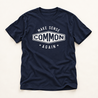A navy blue short-sleeve t-shirt with a white graphic print on the chest that reads 'MAKE SENSE COMMON AGAIN' with stars, laid flat on a light beige background.